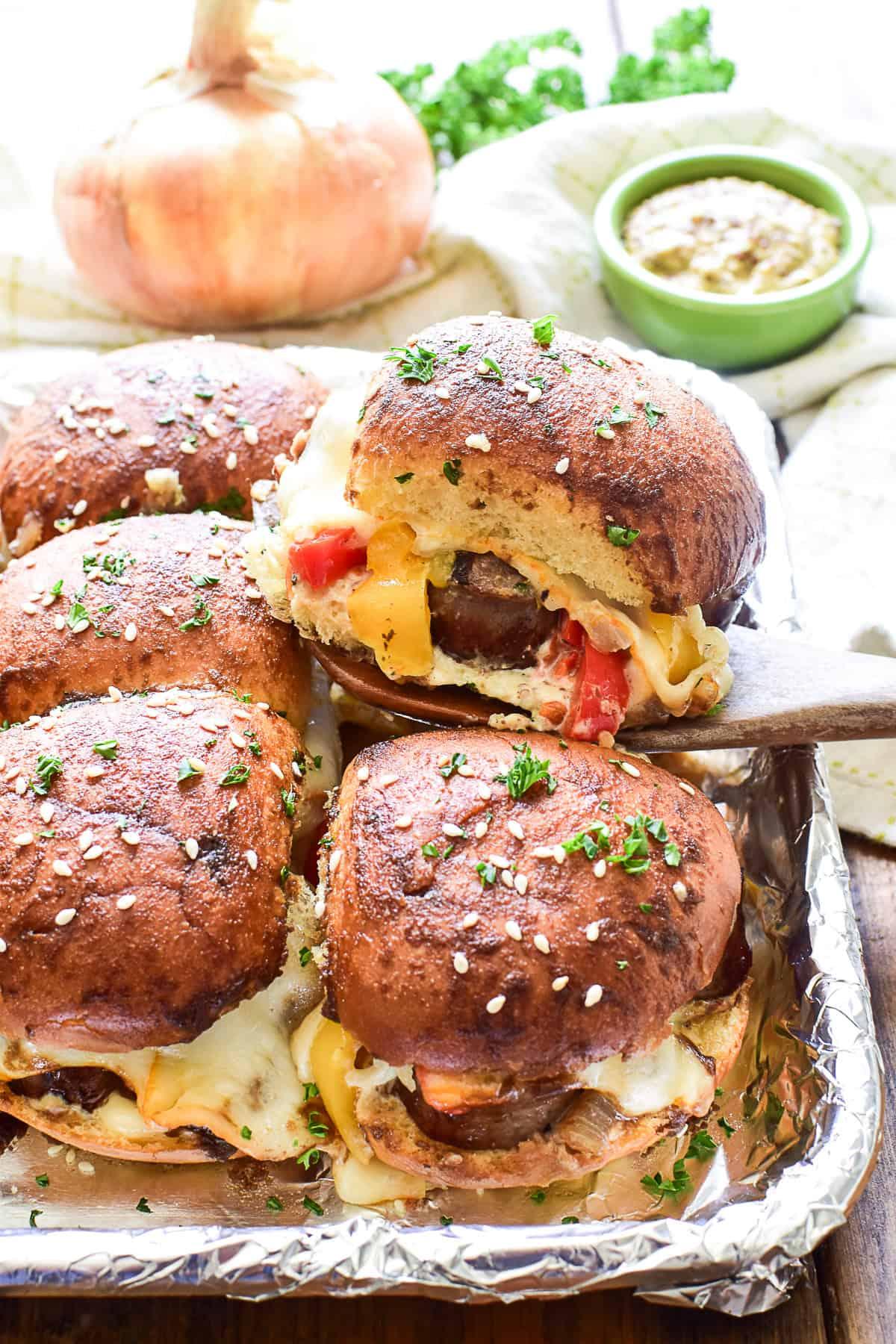 Sausage sliders with melted cheese being served on a wooden board