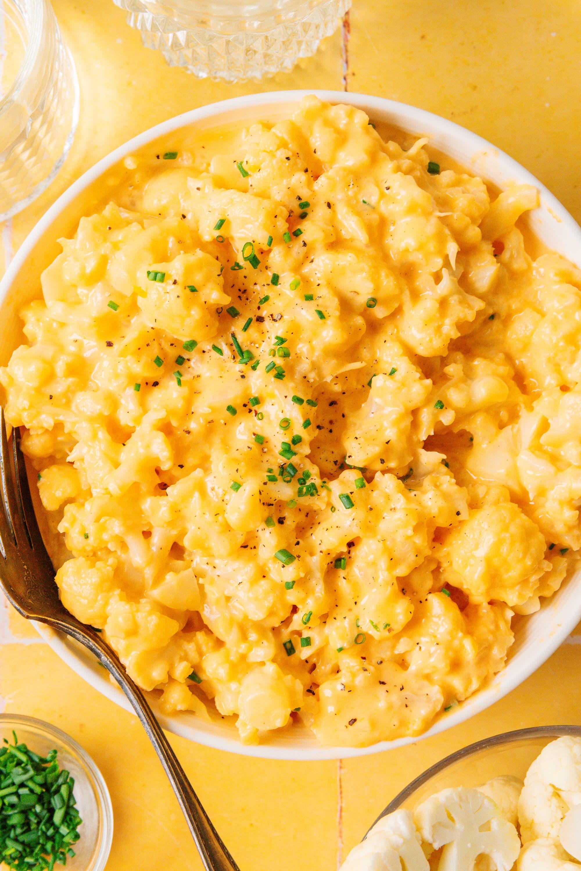 family enjoying cheesy cauliflower mac and cheese at a dinner table, cozy atmosphere
