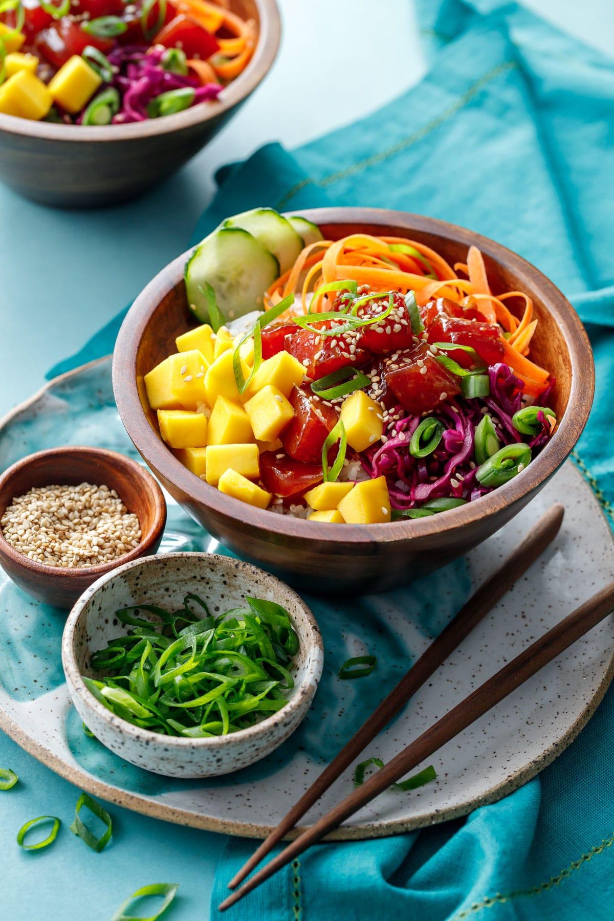 Spicy Tuna Poke Bowl with Mango Salsa on a rustic wooden table, bright and colorful