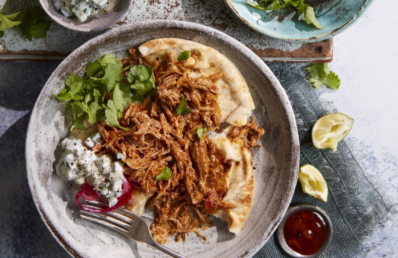 mango curry pulled pork naan served on a plate
