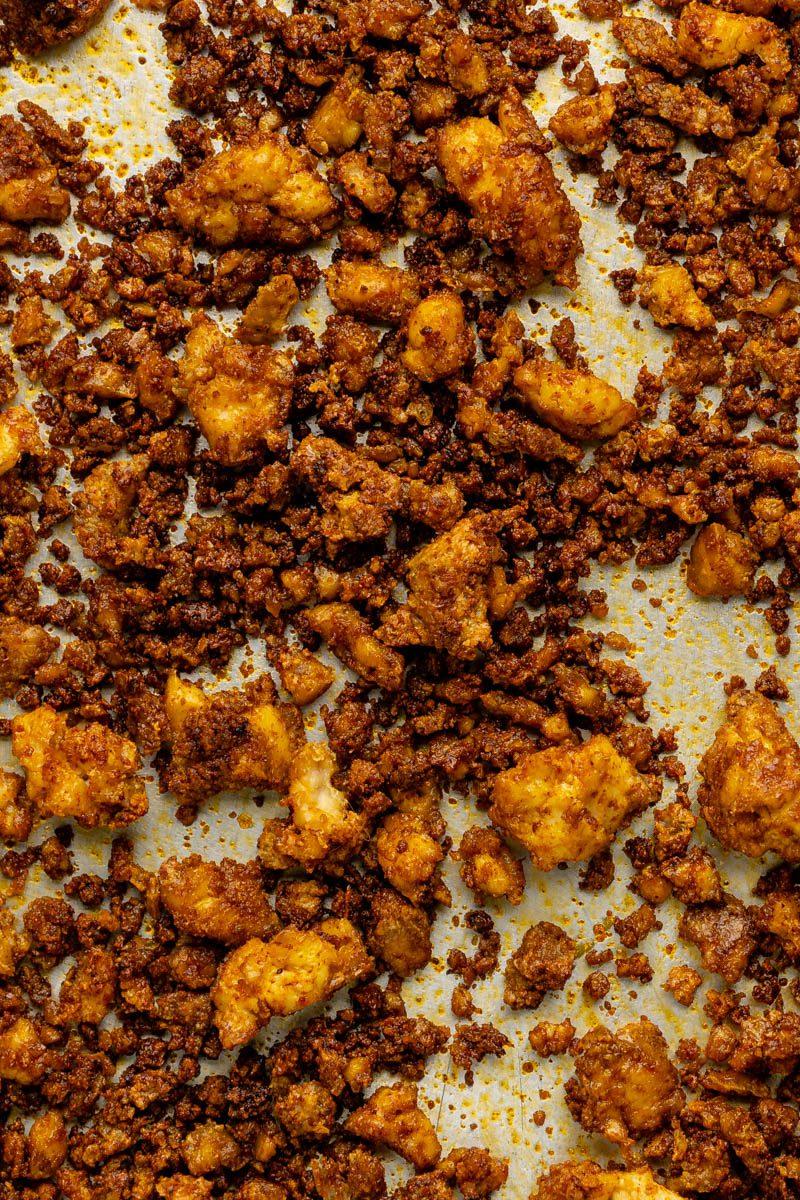 Close up of crumbled tofu being seasoned with spices.