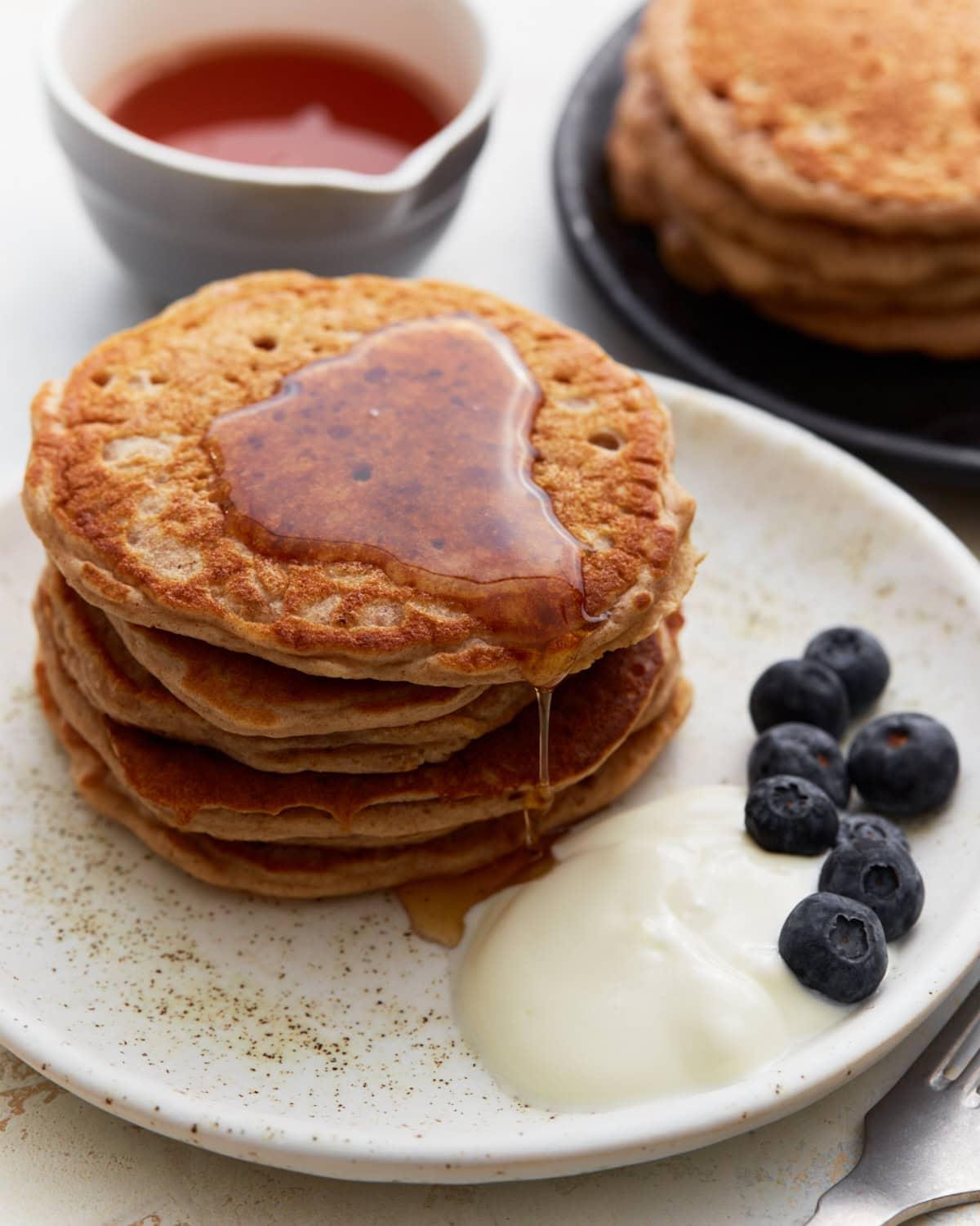 stack of freshly made buckwheat pancakes with syrup and berries
