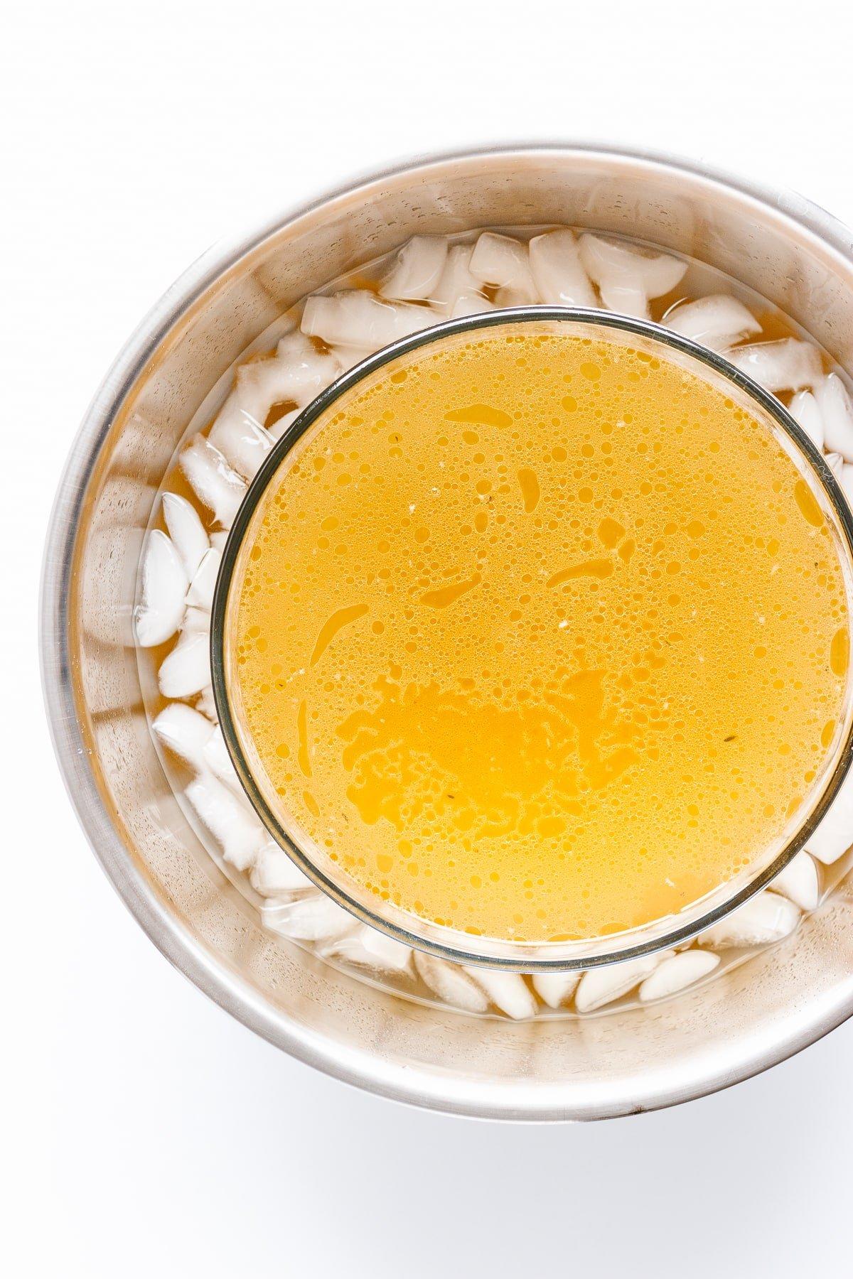 a bowl of warm bone broth with visible steam and a spoon dipping into it