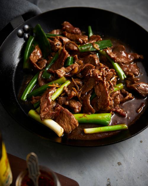 beef stir-fry sizzling in a wok