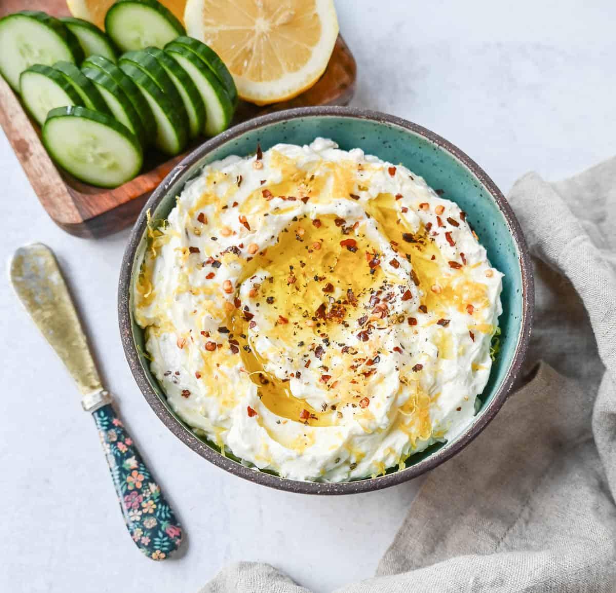 Fluffy whipped feta cheese in a bowl, garnished with lemon zest