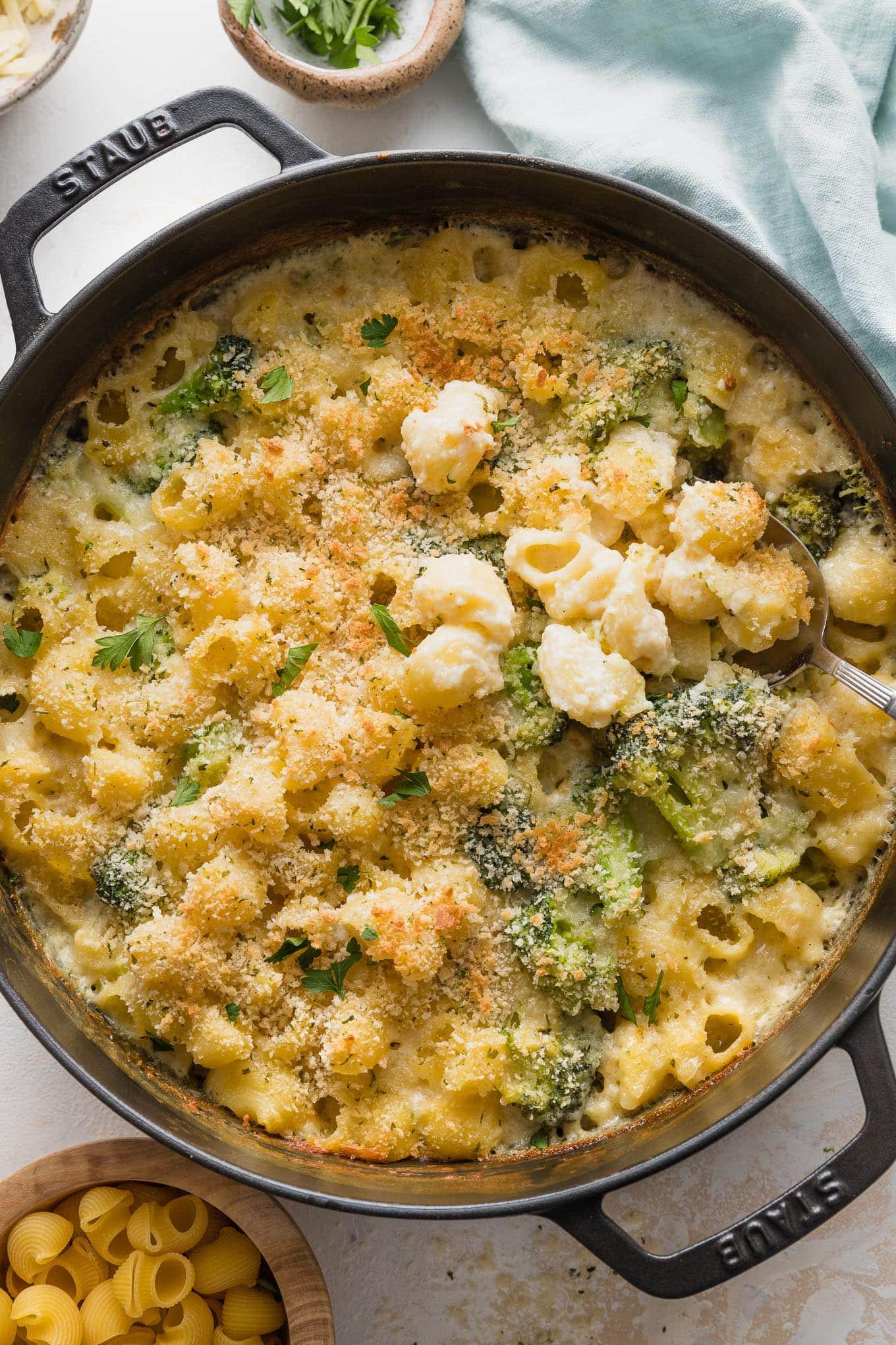 Creamy mac and cheese with roasted broccoli and other colorful vegetables in a baking dish