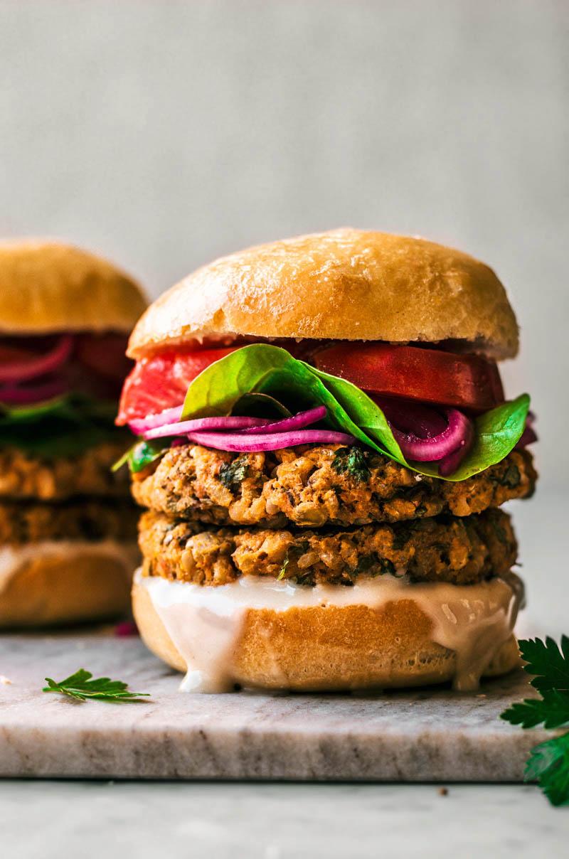 Curried sweet potato and chickpea masala burger served on a whole wheat bun with fresh toppings