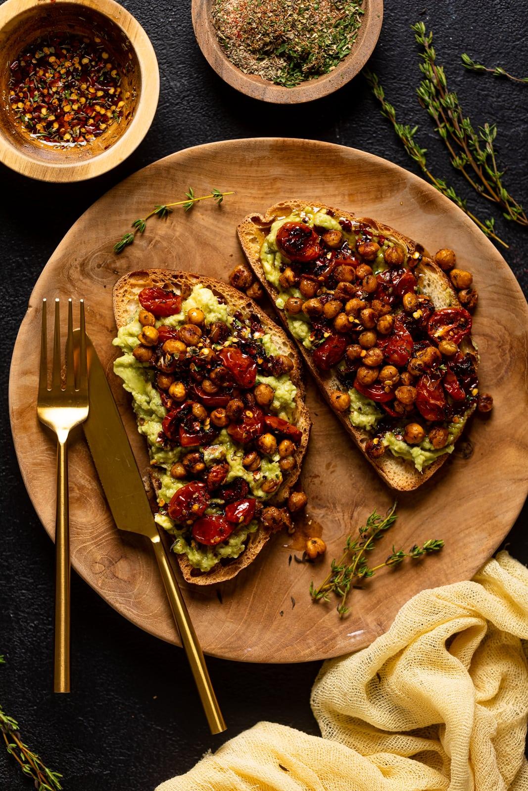 Overhead shot of avocado toast with hot sauce and various toppings