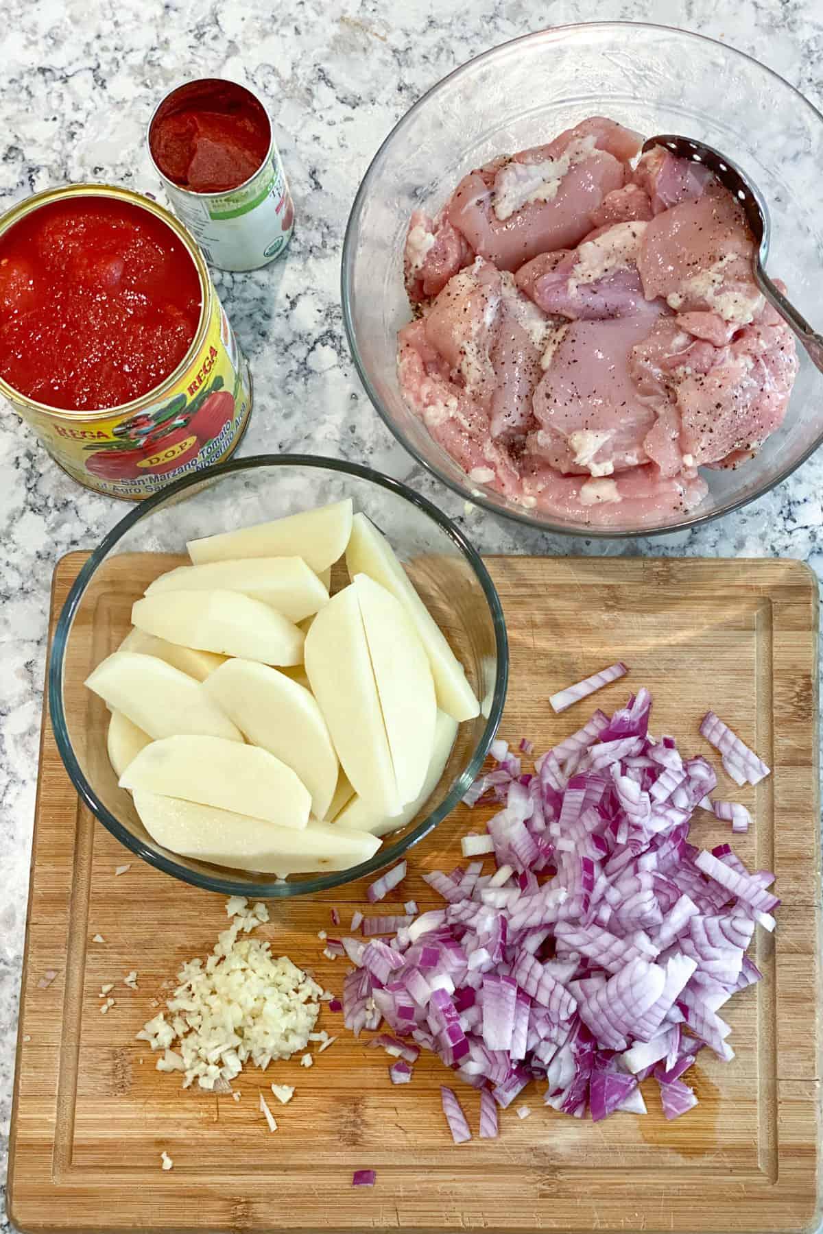 ingredients for chicken stew on a wooden countertop