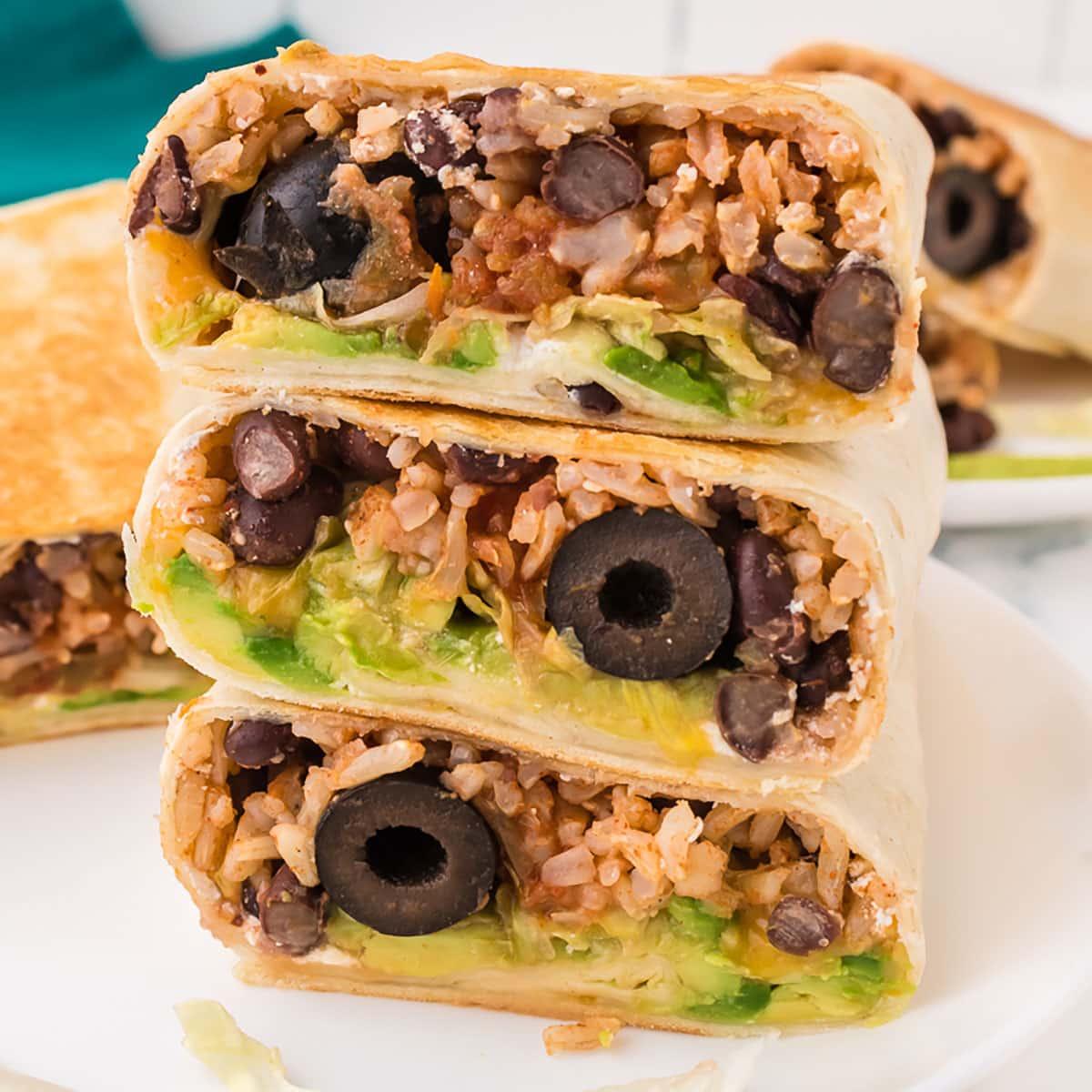 Overhead shot of all the fresh ingredients laid out for the Rice Riot Wrap, including rice, chicken, black beans, salsa, tortillas, cheese, and avocado.