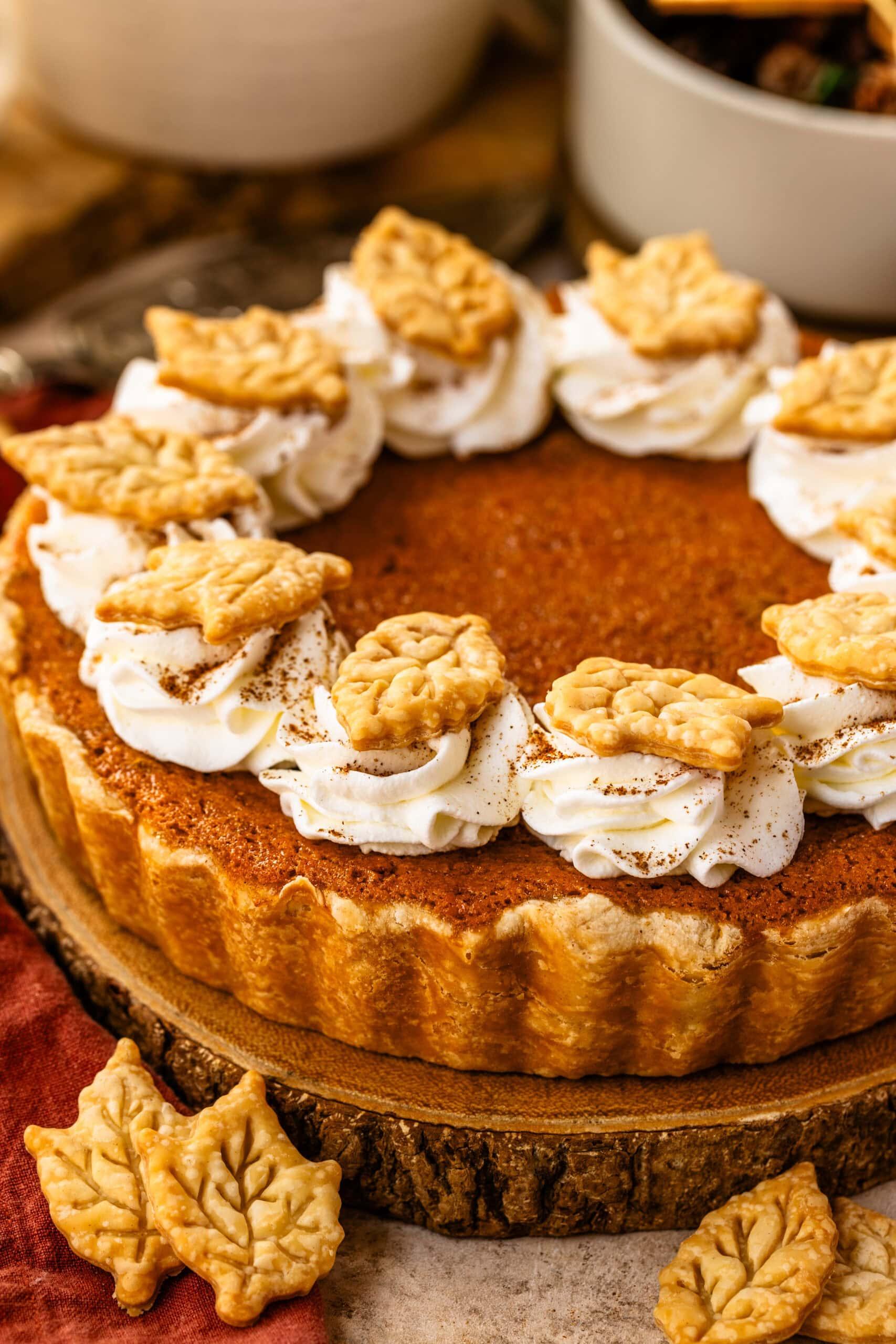 A beautifully baked sweet potato pie with a golden crust and smooth, creamy filling, garnished with a dollop of whipped cream on a rustic wooden table, cozy setting