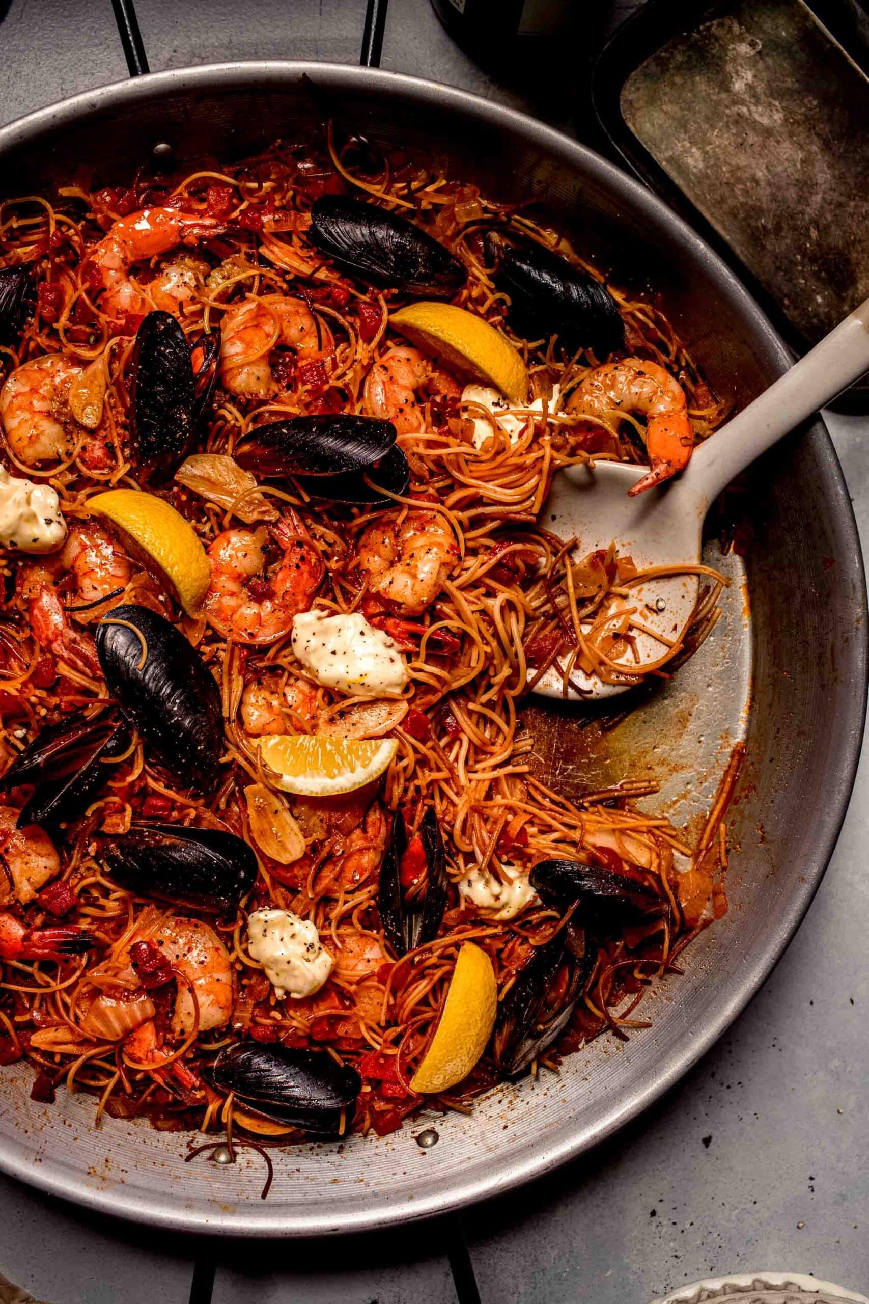 Overhead shot of a paella pan filled with Fideuà Noodles, chicken, chorizo, and vegetables