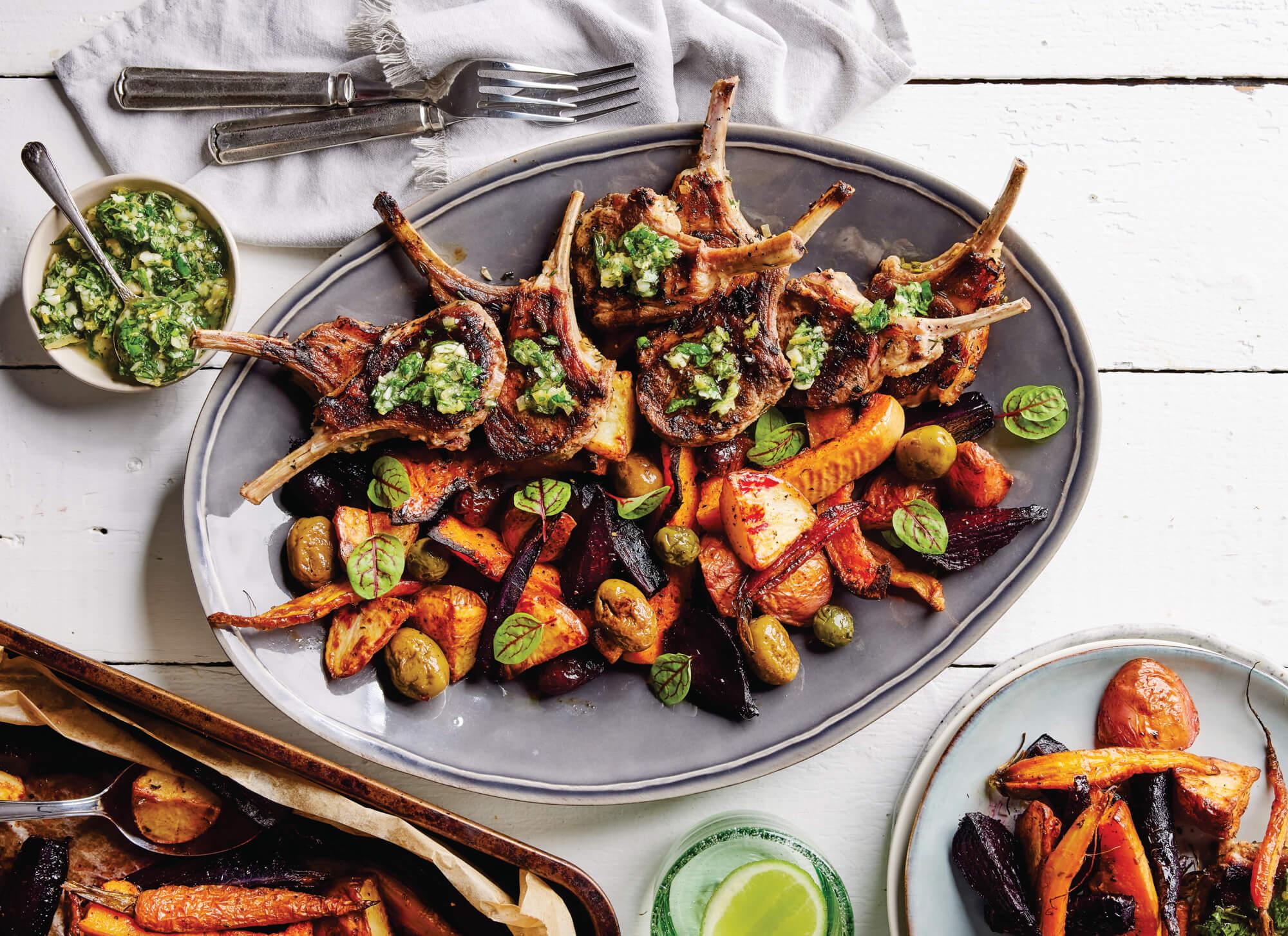 plated basil-crusted lamb chops with a side of roasted vegetables