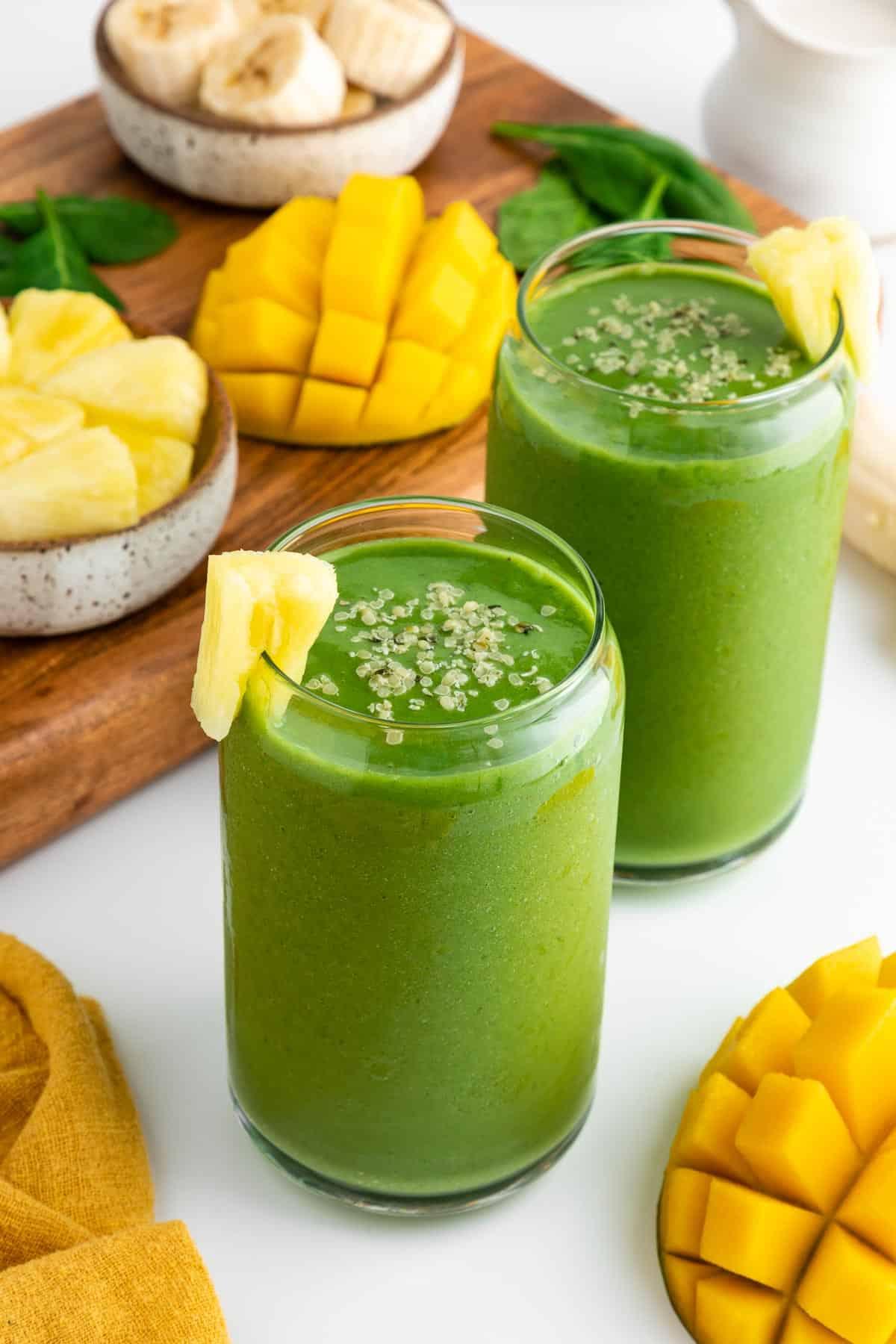 Vibrant green smoothie with visible mango chunks and barley