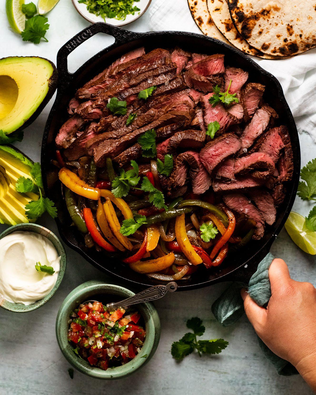 A delicious plate of beef fajitas with all the fixings