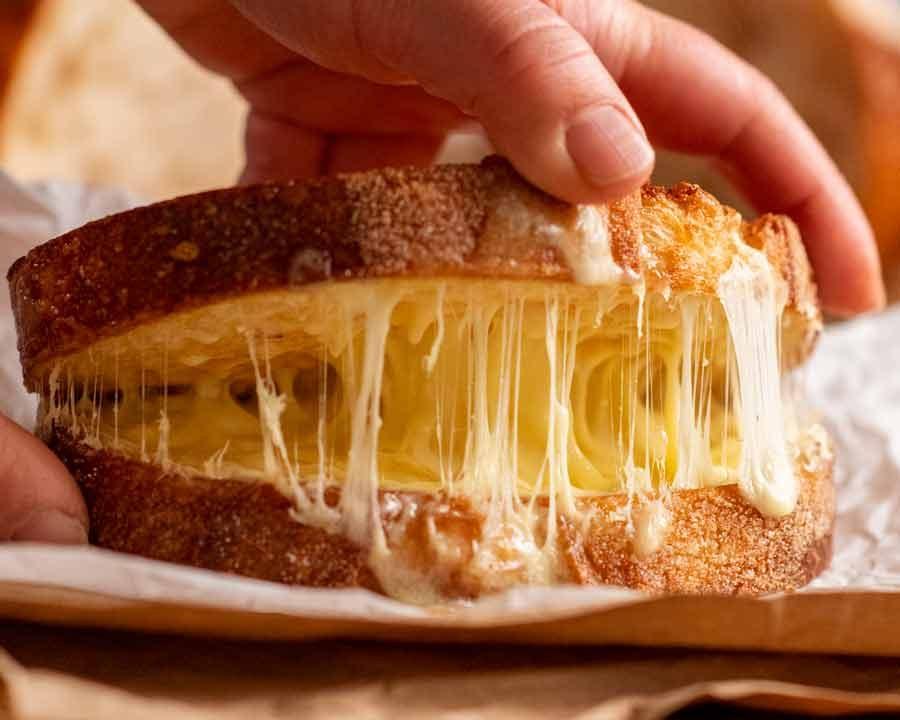Grilled cheese sandwich being pulled apart, showing melted cheese