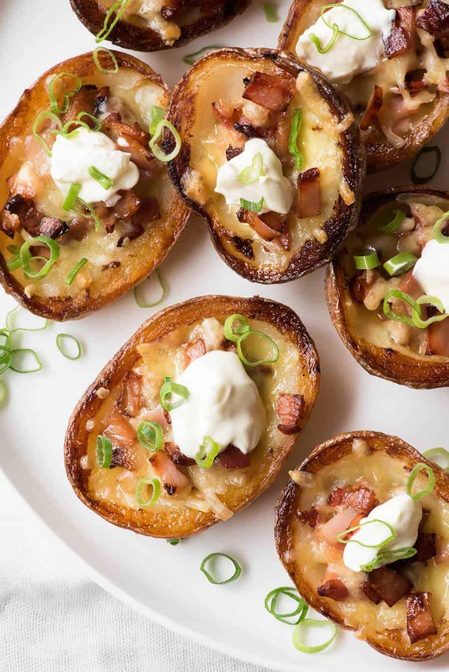 Close-up shot of a plate of crispy potato skins with bacon and cheese