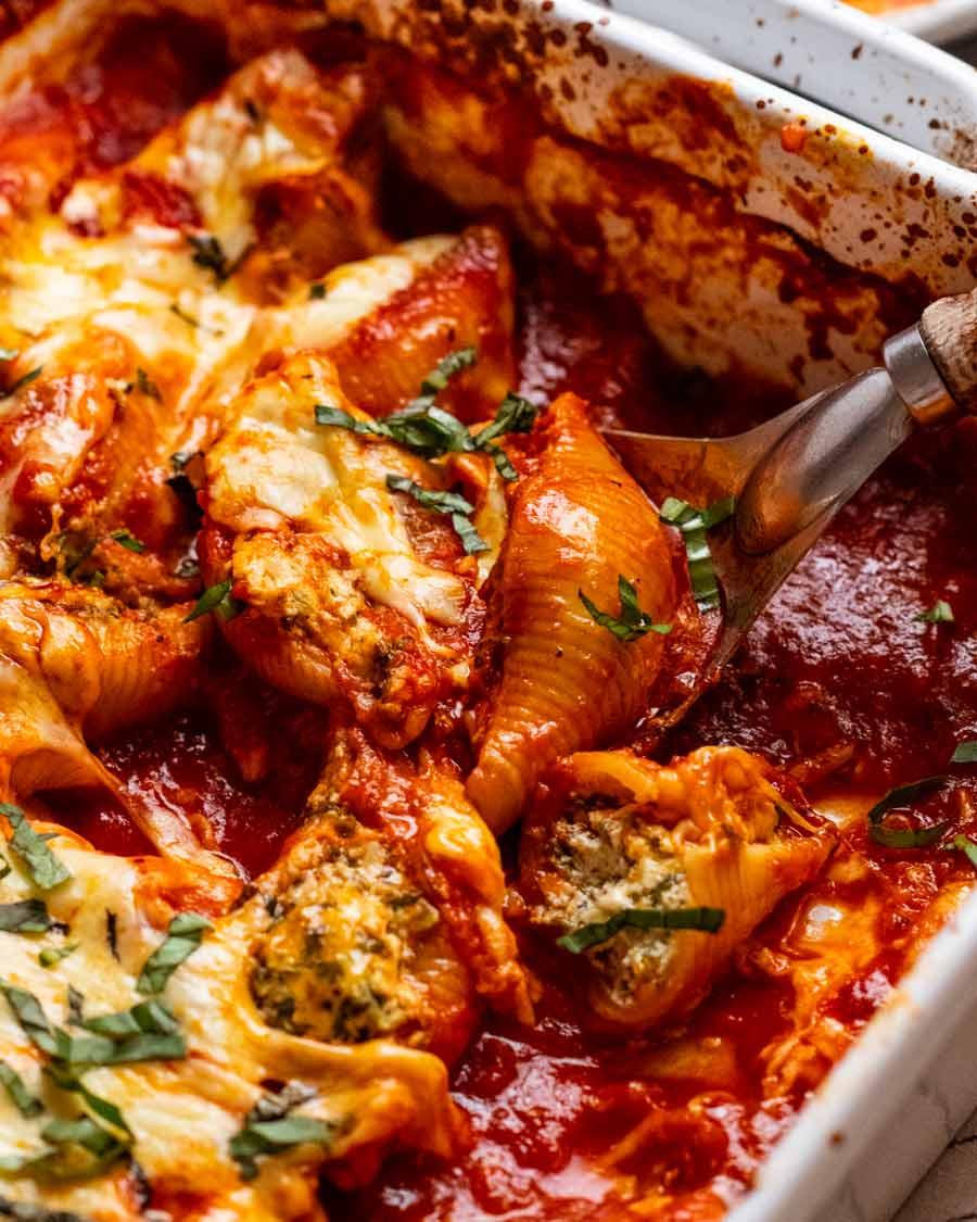 close-up of spinach and ricotta stuffed shells in a baking dish