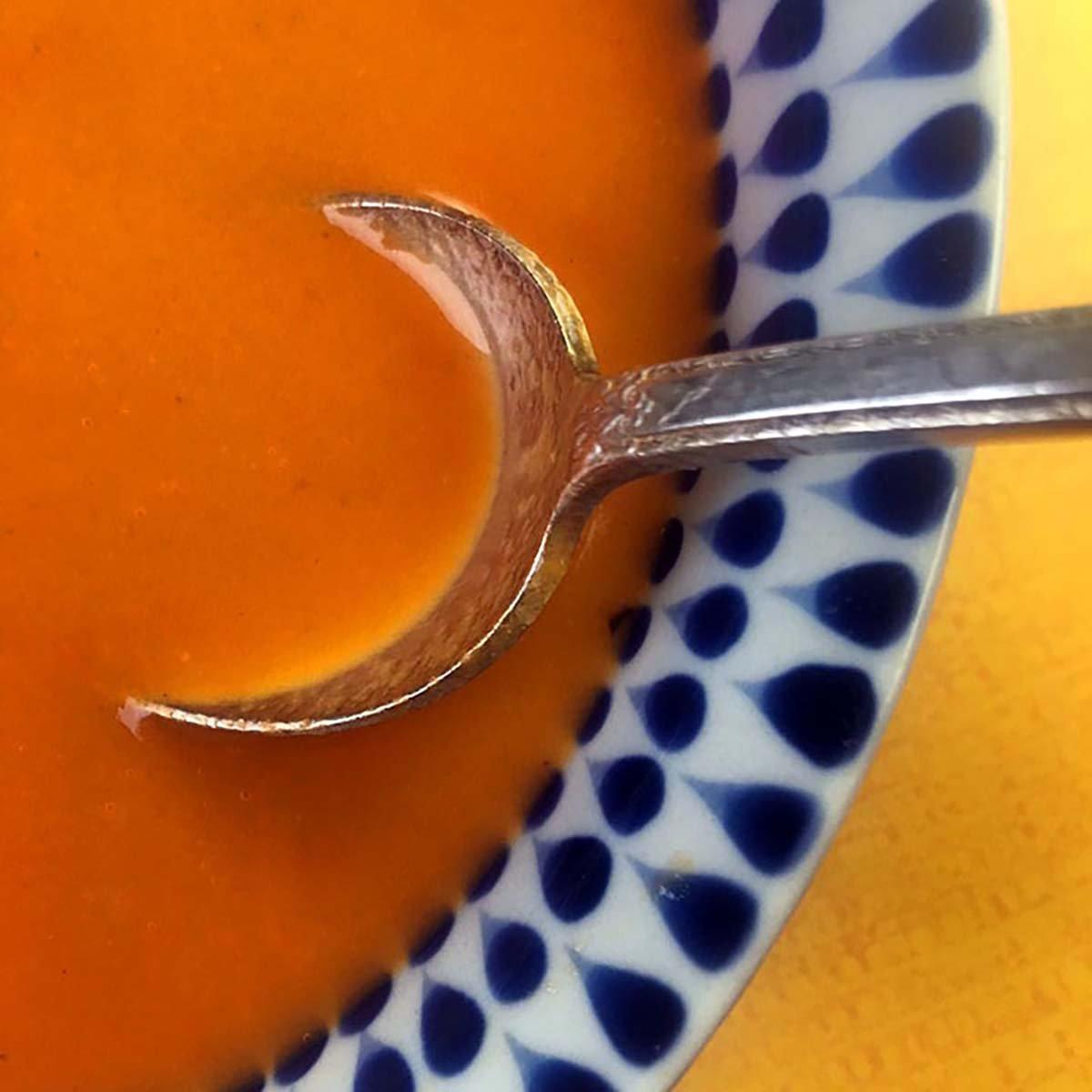 Close-up shot of a spoonful of Keto Hamster Soup being lifted from a bowl, showcasing the texture and ingredients