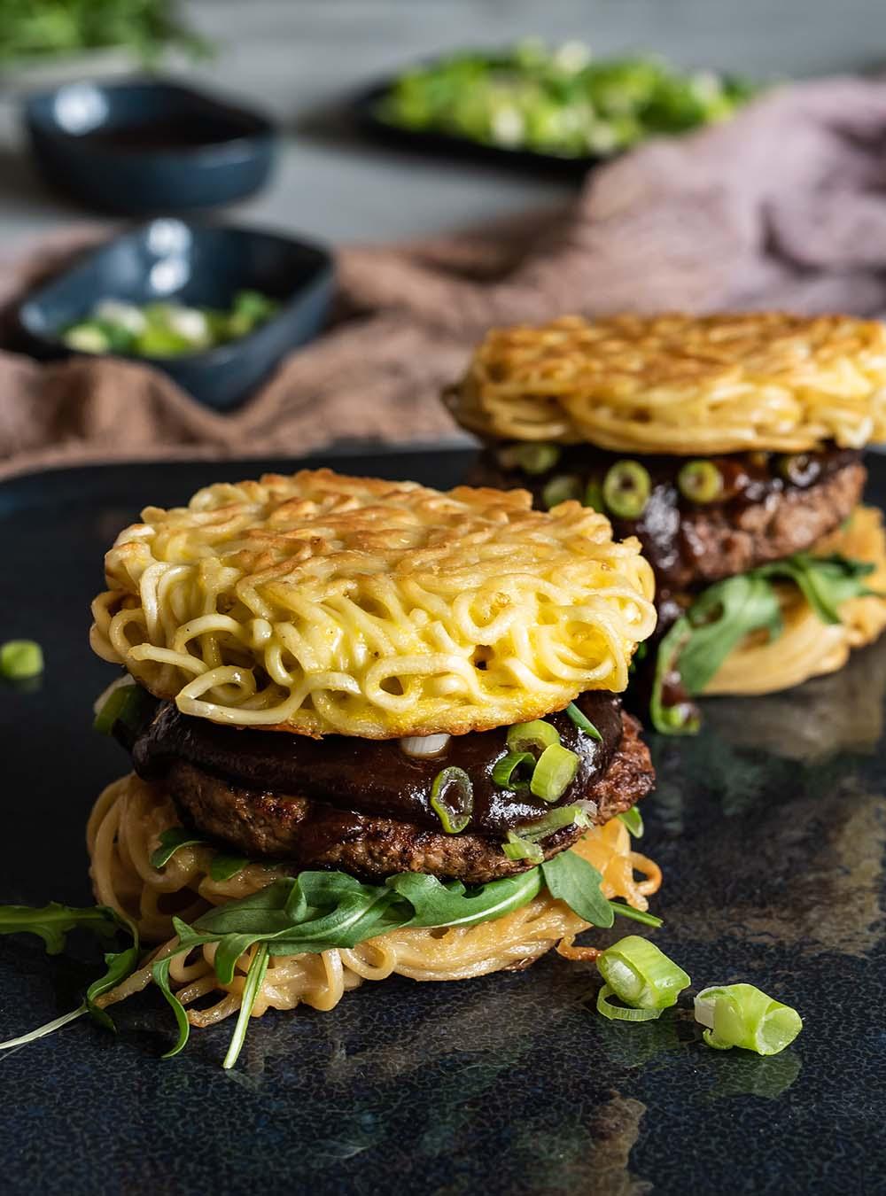 A beautifully styled image of a Ramen Burger with sautéed spinach and ricotta, ready to eat
