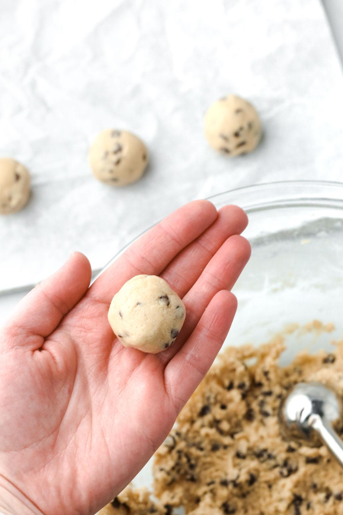 Hands shaping cookie dough into balls