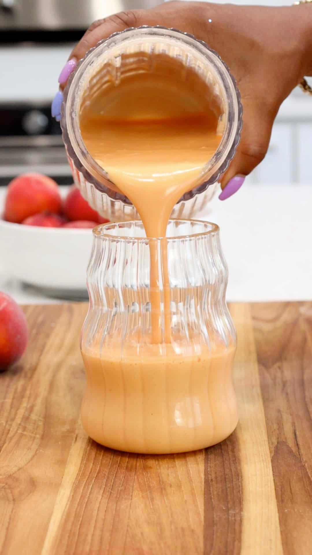 salmonberry peach smoothie being poured into a glass