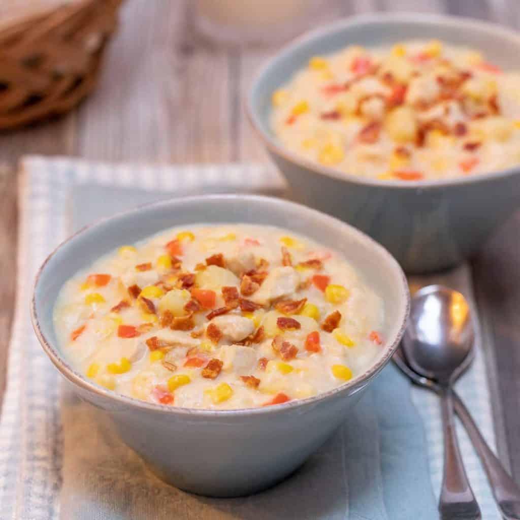 group of people enjoying bowls of chicken corn chowder at a dinner table