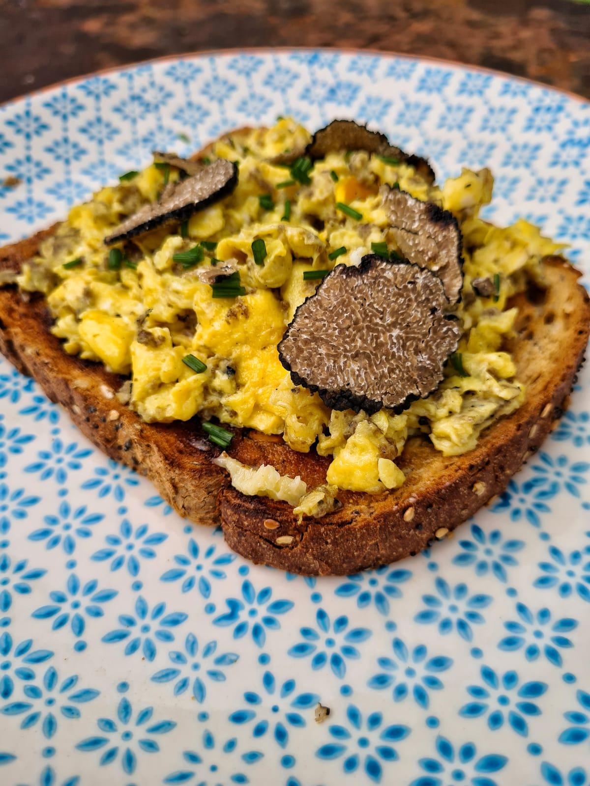 Close-up of fresh black truffles being shaved over a tofu scramble
