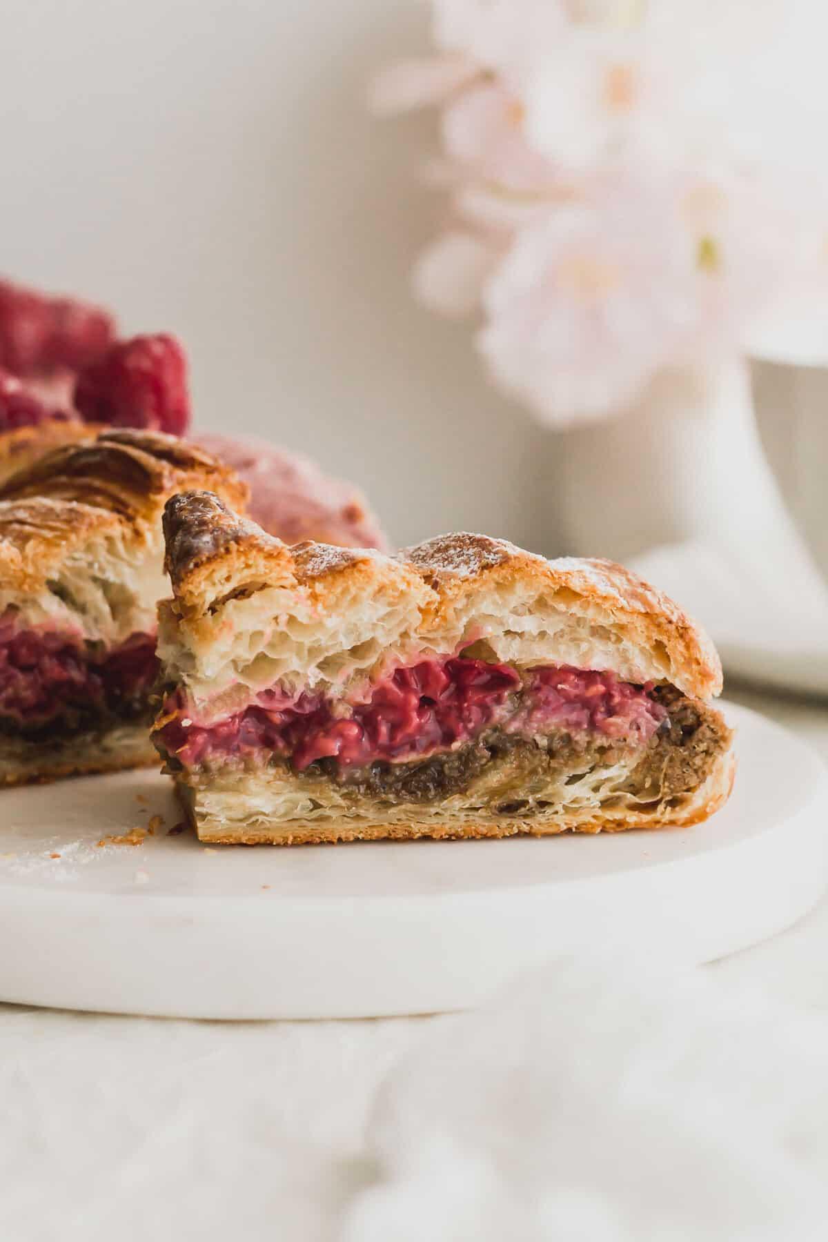 close up of a baker adding raspberry filling to croissants
