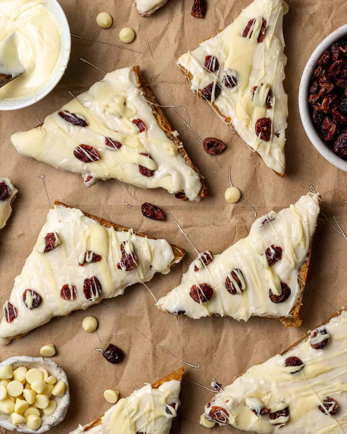 close-up of raw cranberry bliss bar batter in a square baking pan before baking, showing vivid cranberries and melted white chocolate