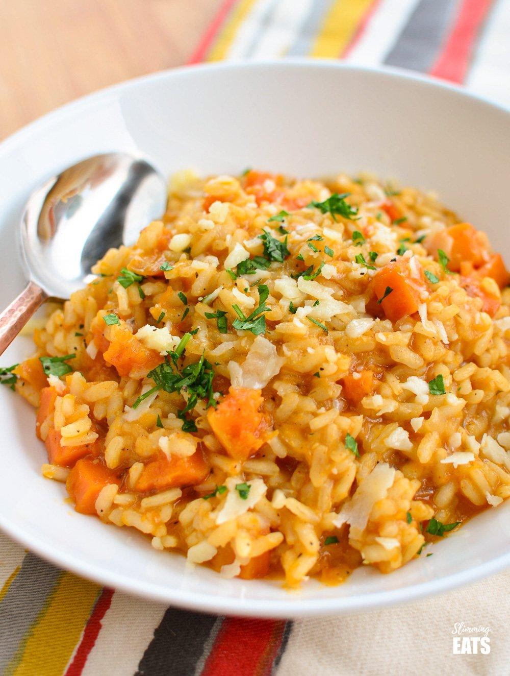 A close-up of a bowl of vibrant orange butternut squash risotto.
