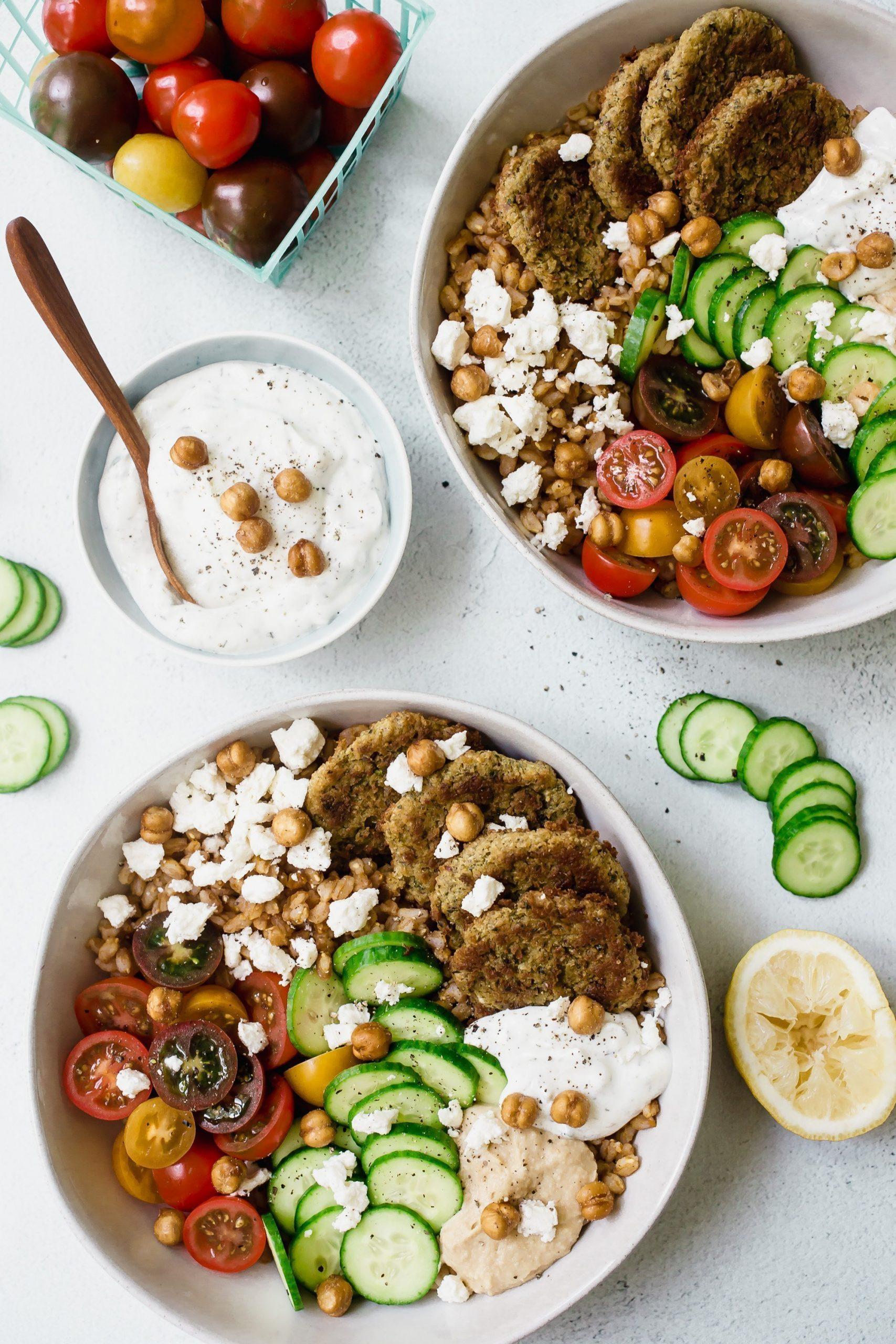 A table set with several bowls of falafel, garnished with fresh herbs and vegetables