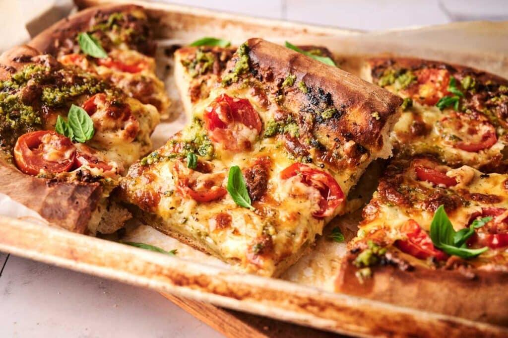 freshly baked Present Ribbon Pesto Pizza on a wooden board