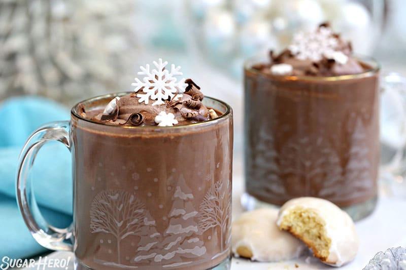 overhead view of several mugs of mint hot chocolate with festive decorations