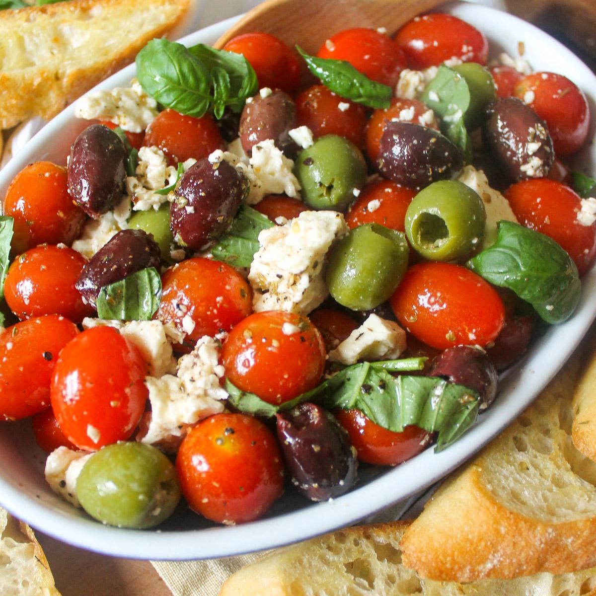 close-up of cherry tomato and olive tagine with feta cheese, garnished with fresh herbs