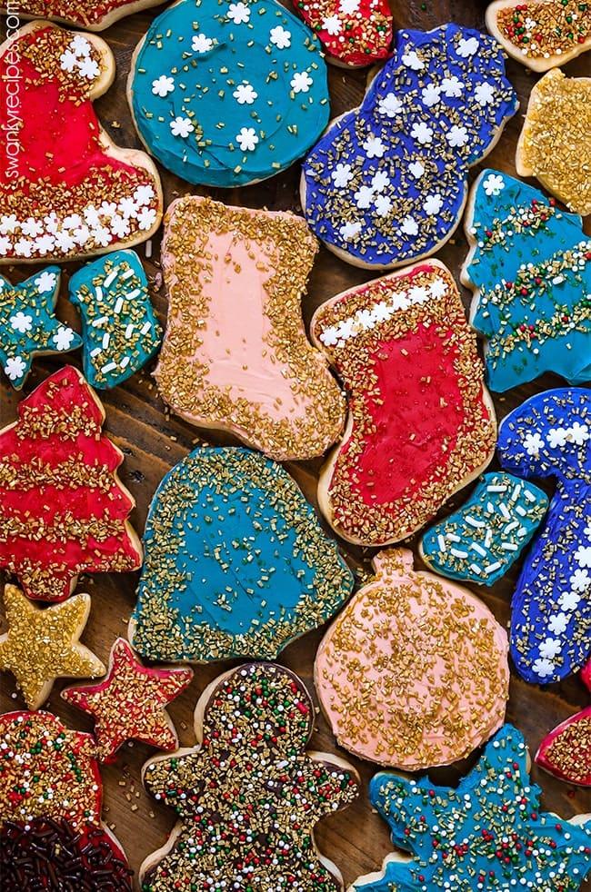 Various Christmas cookie cutters laid out on rolled sugar cookie dough