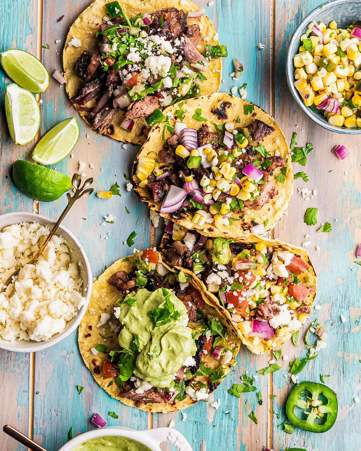 overhead shot of a table filled with Texas smoked brisket tacos and toppings