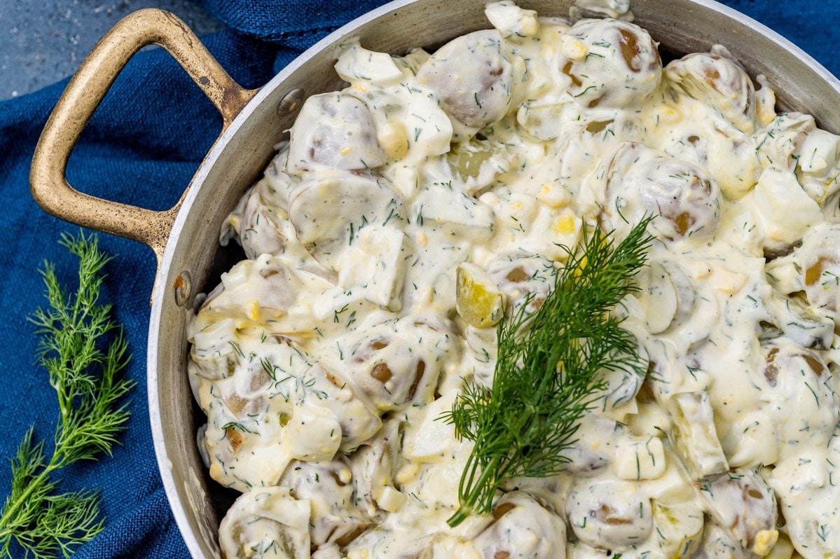Close-up shot of creamy dill potato salad, garnished with fresh dill