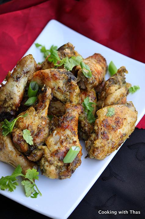 close up of the cooked wings on a platter, garnished with mint