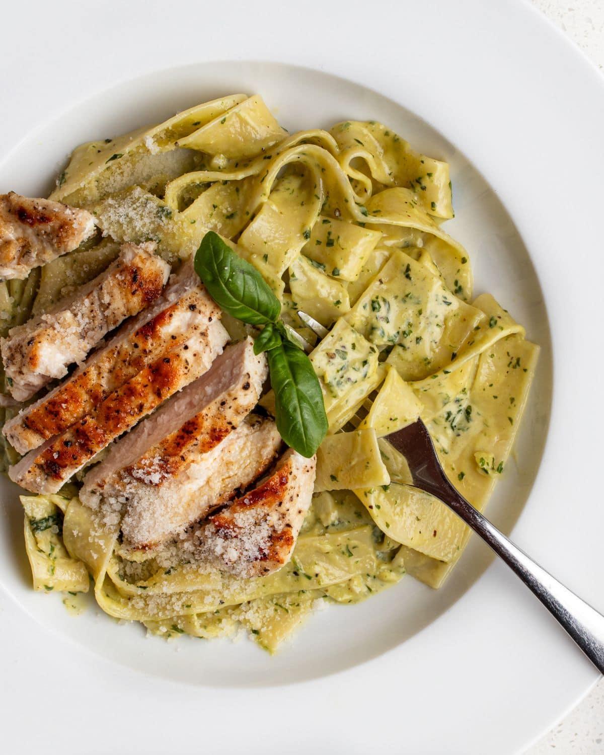 appetizing creamy pesto chicken with pasta on a plate