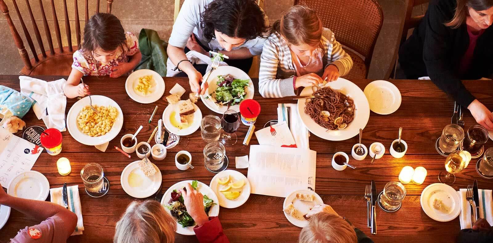 family gathered around a table enjoying a meal of easter lamb with blood orange and fennel