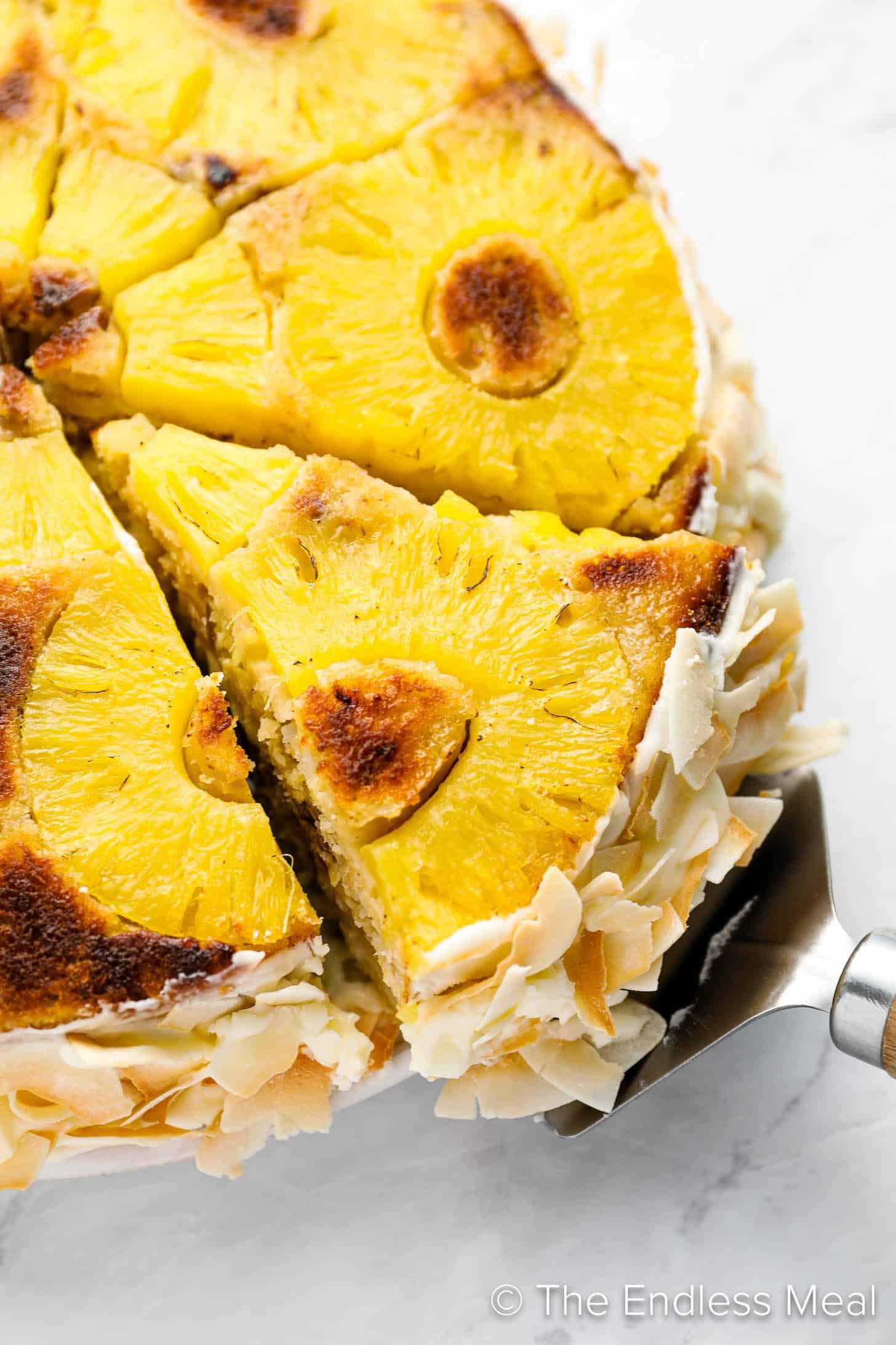 Close-up shot of a slice of pineapple upside-down cake with coconut cream frosting