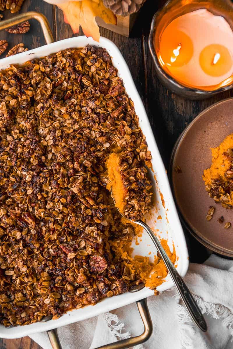 Warm, baked maple sweet potato casserole with pecan crunch, steam rising, served on a festive table