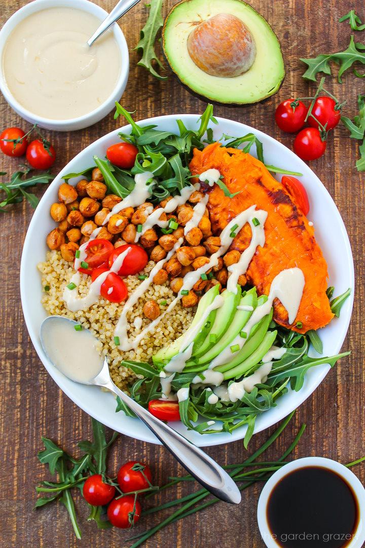 Sweet potato and quinoa bowl ingredients laid out on a wooden table