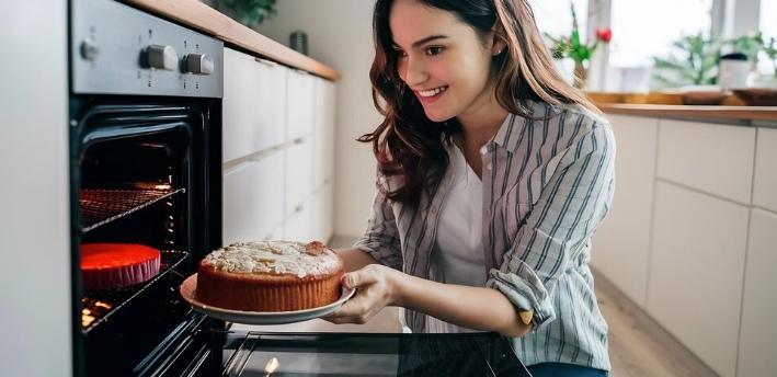 Person expertly timing a cake in the oven