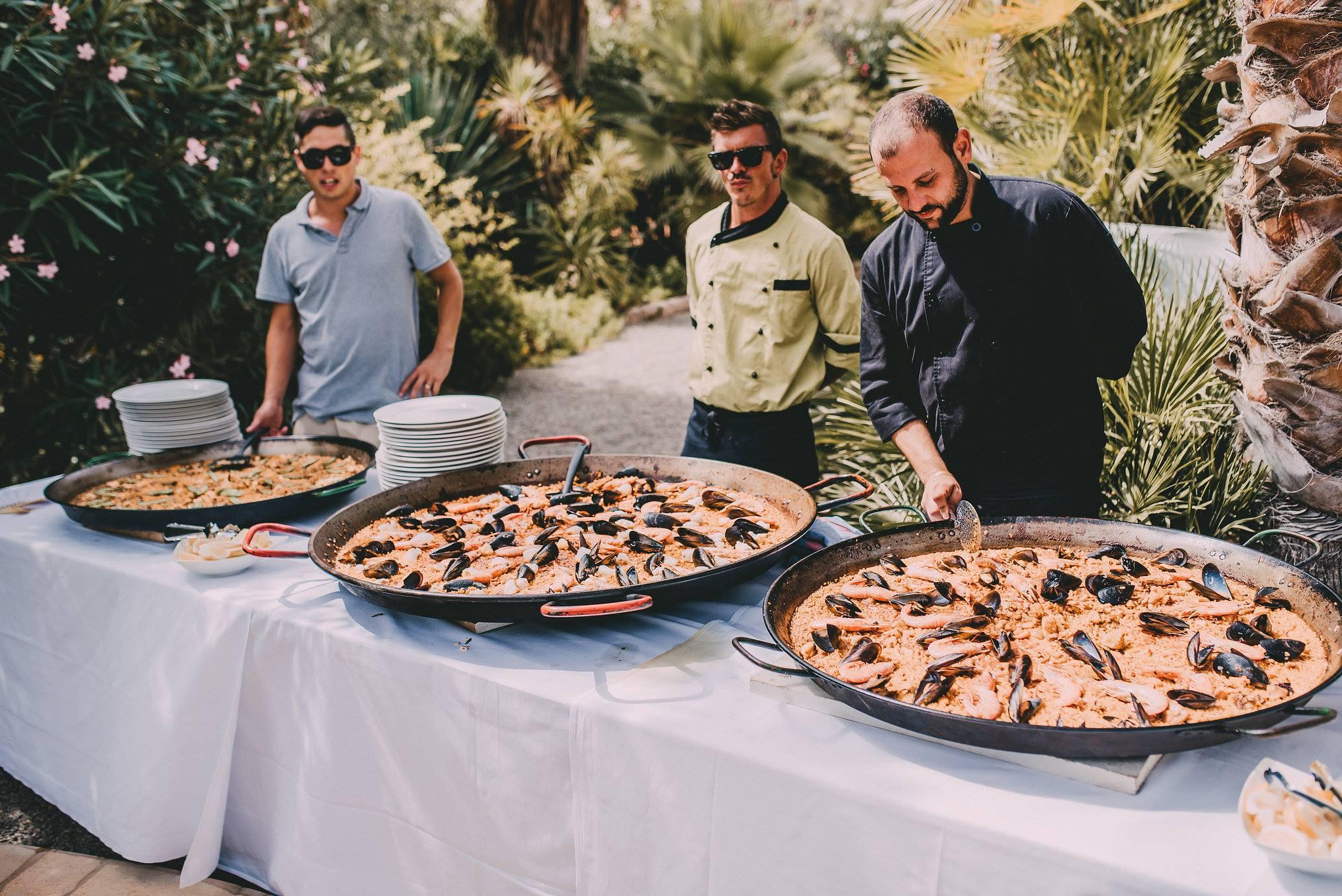 group of people enjoying paella empanadas at a party