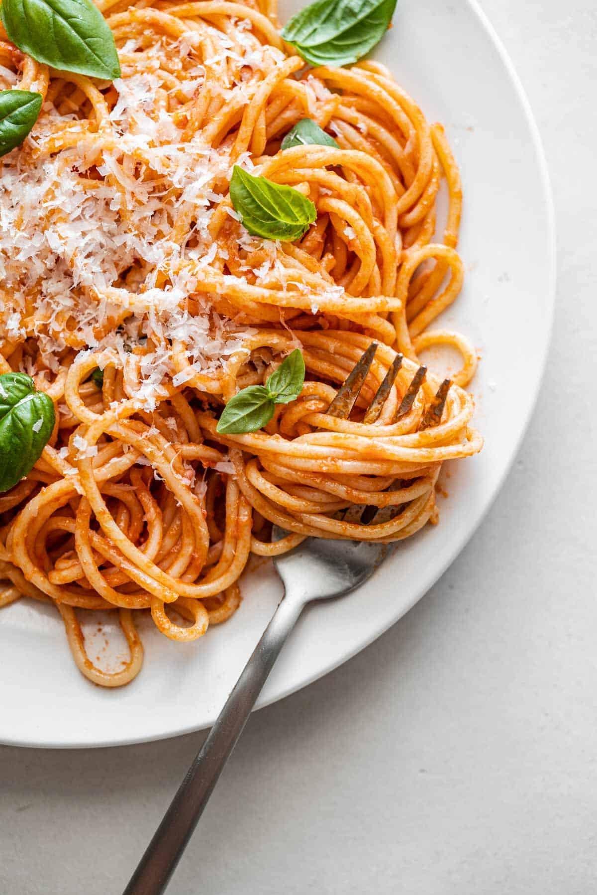 plate of spaghetti with sauce and parmesan cheese