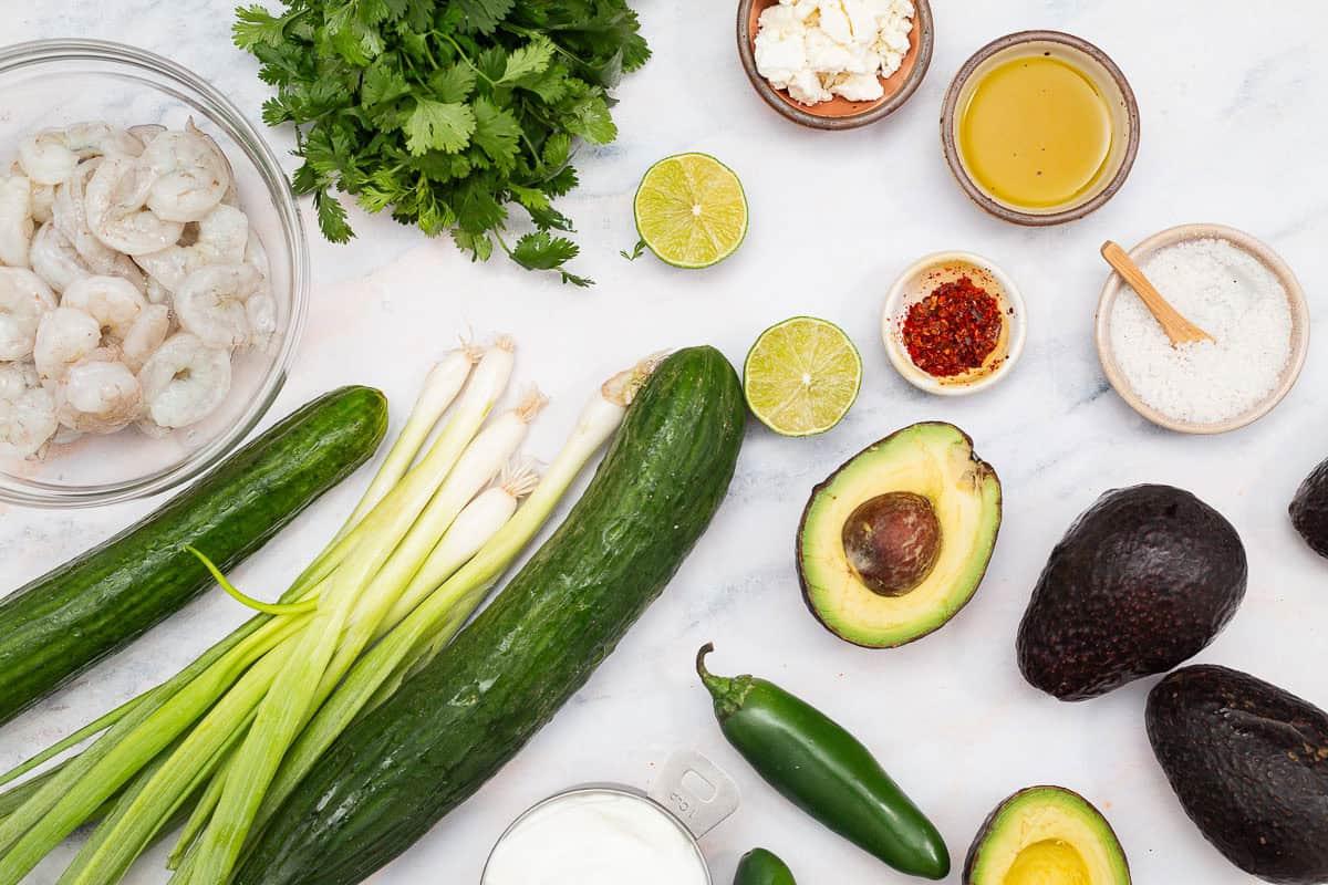 overhead shot of ingredients for keto avocado and cucumber soup: avocados, cucumber, lime, cilantro