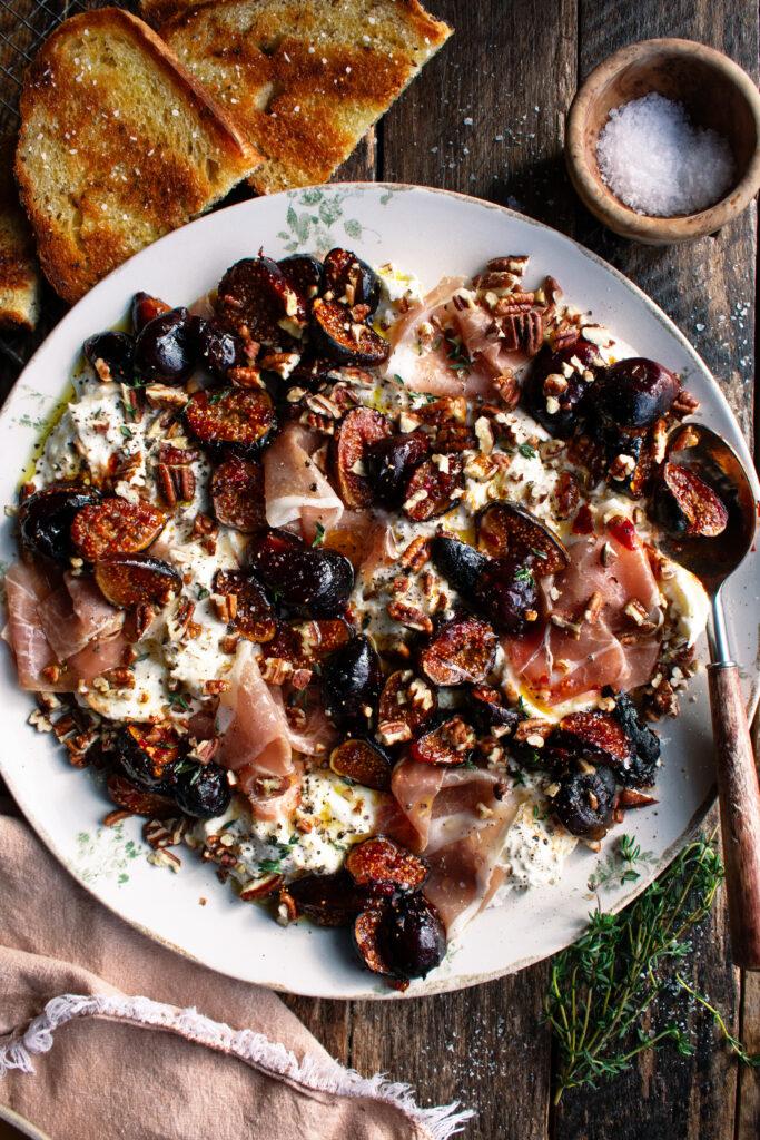 fig balsamic reduction being drizzled over a cheese board