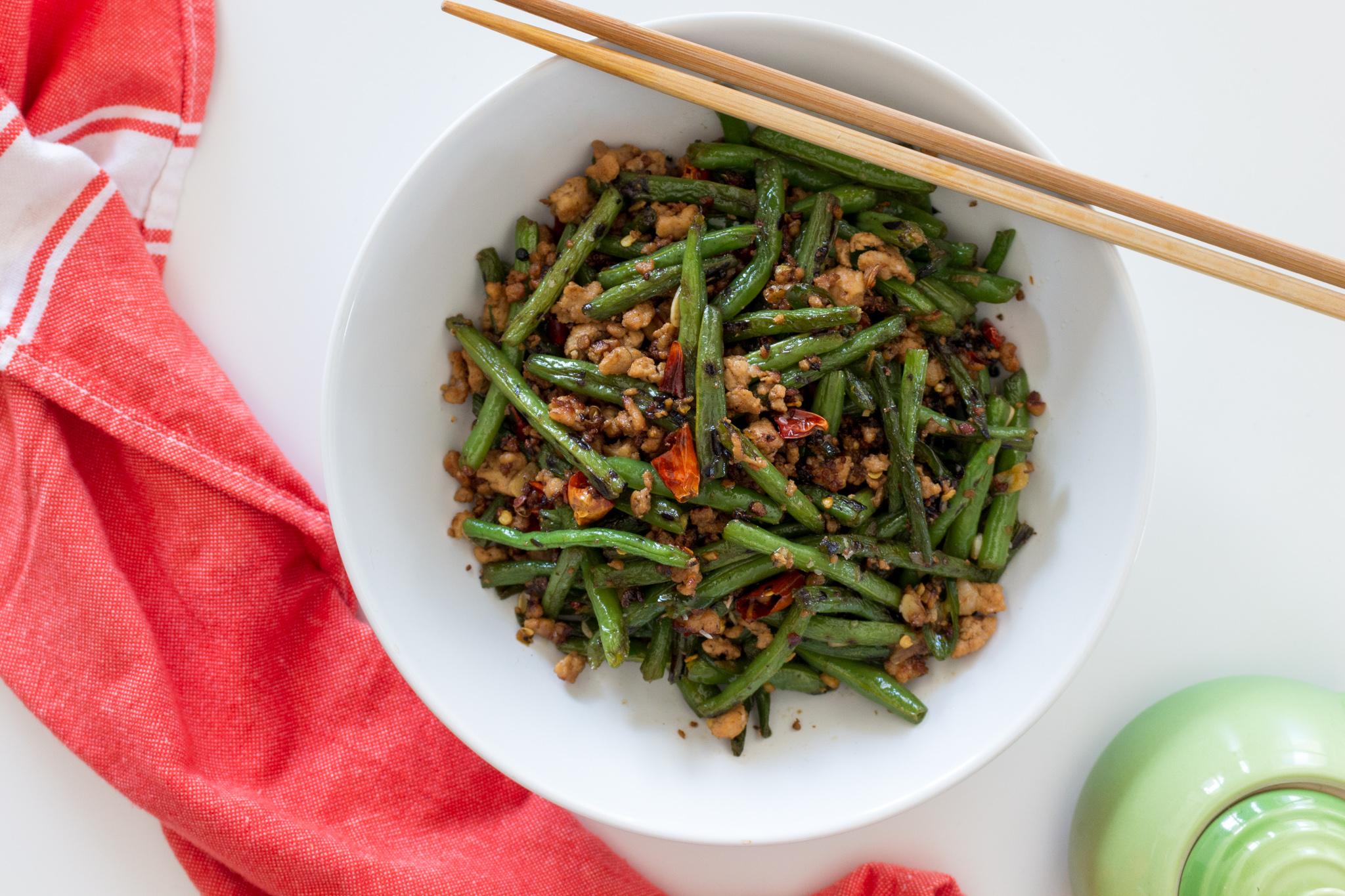 Overhead shot of a wok with green beans being stir-fried